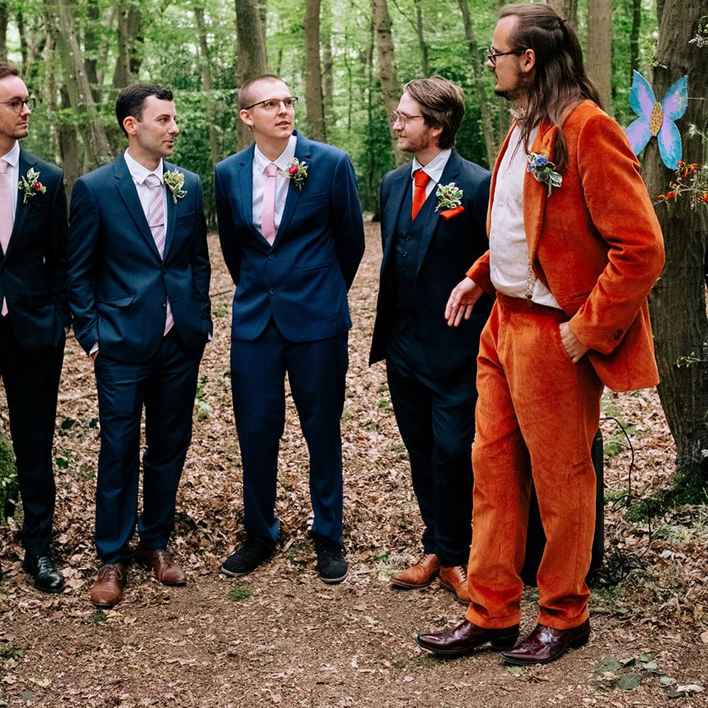 groomsmen-in-navy-suits-with-groom-in-orange-suit
