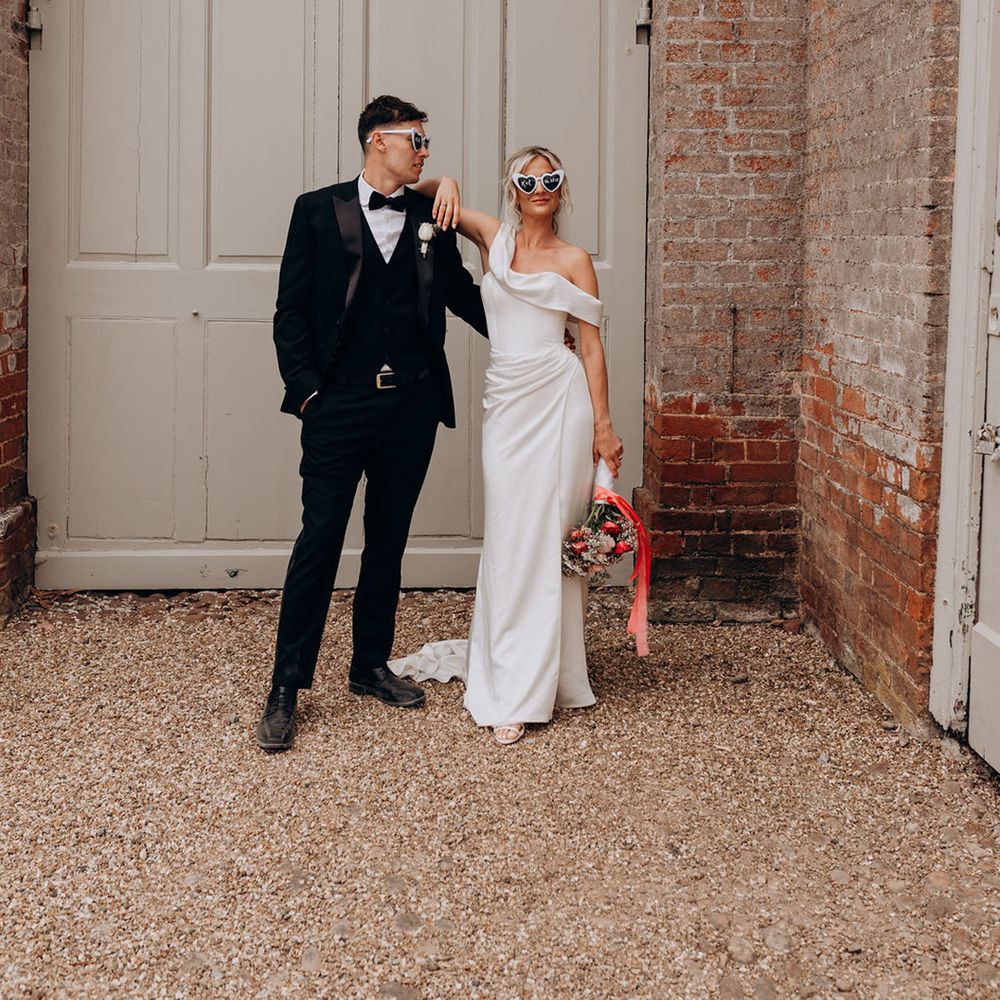 couple-poses-wearing-wedding-sunglasses