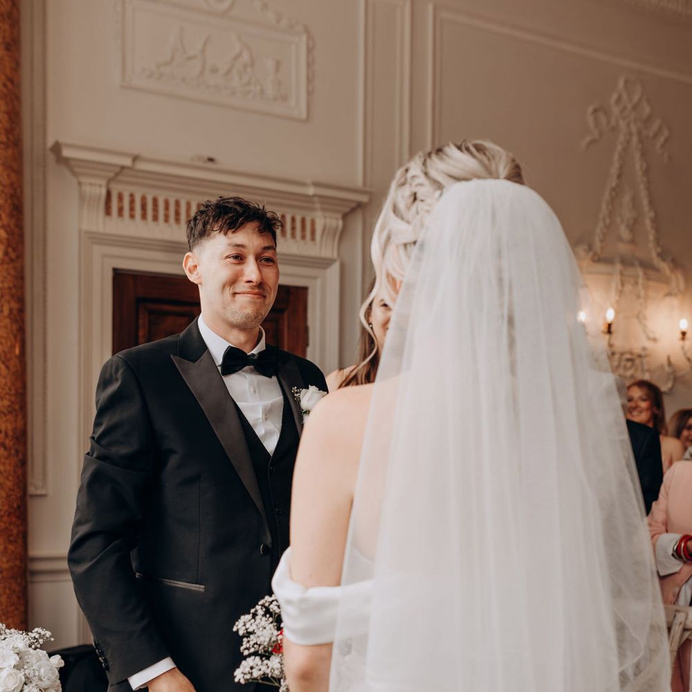 groom-in-black-tuxedo-with-bride-wearing-veil-with-blusher