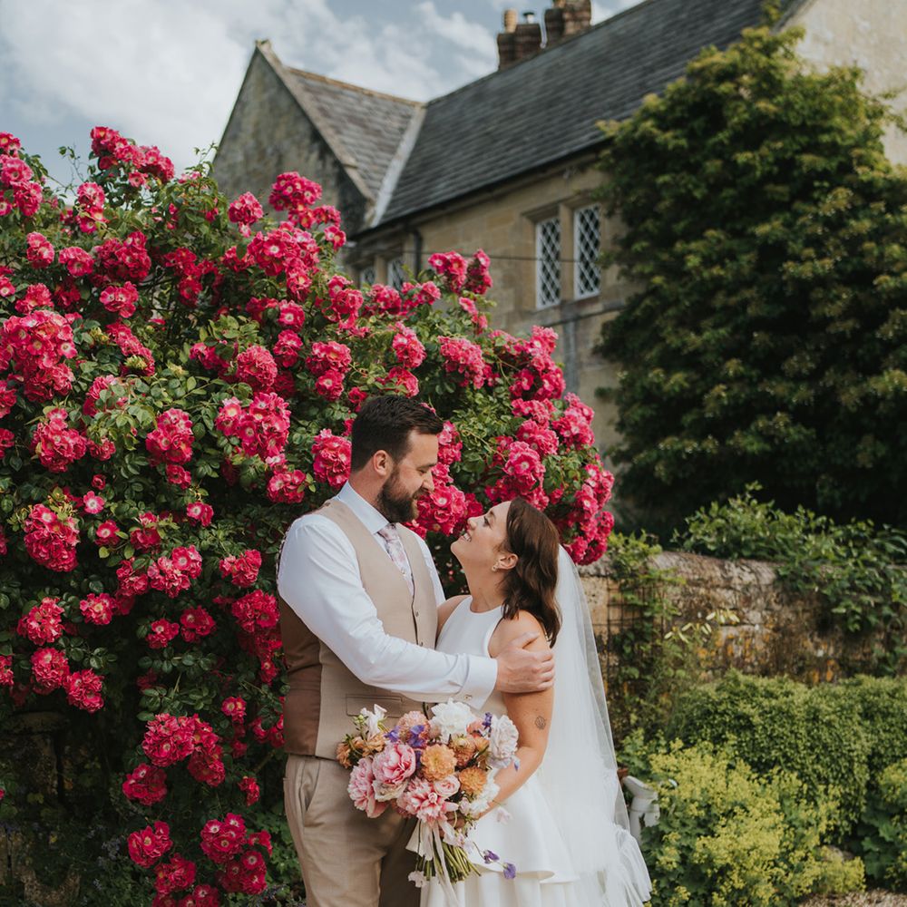 bride-in-ruffle-wedding-dress-looking-up-at-groom-in-beige-suit
