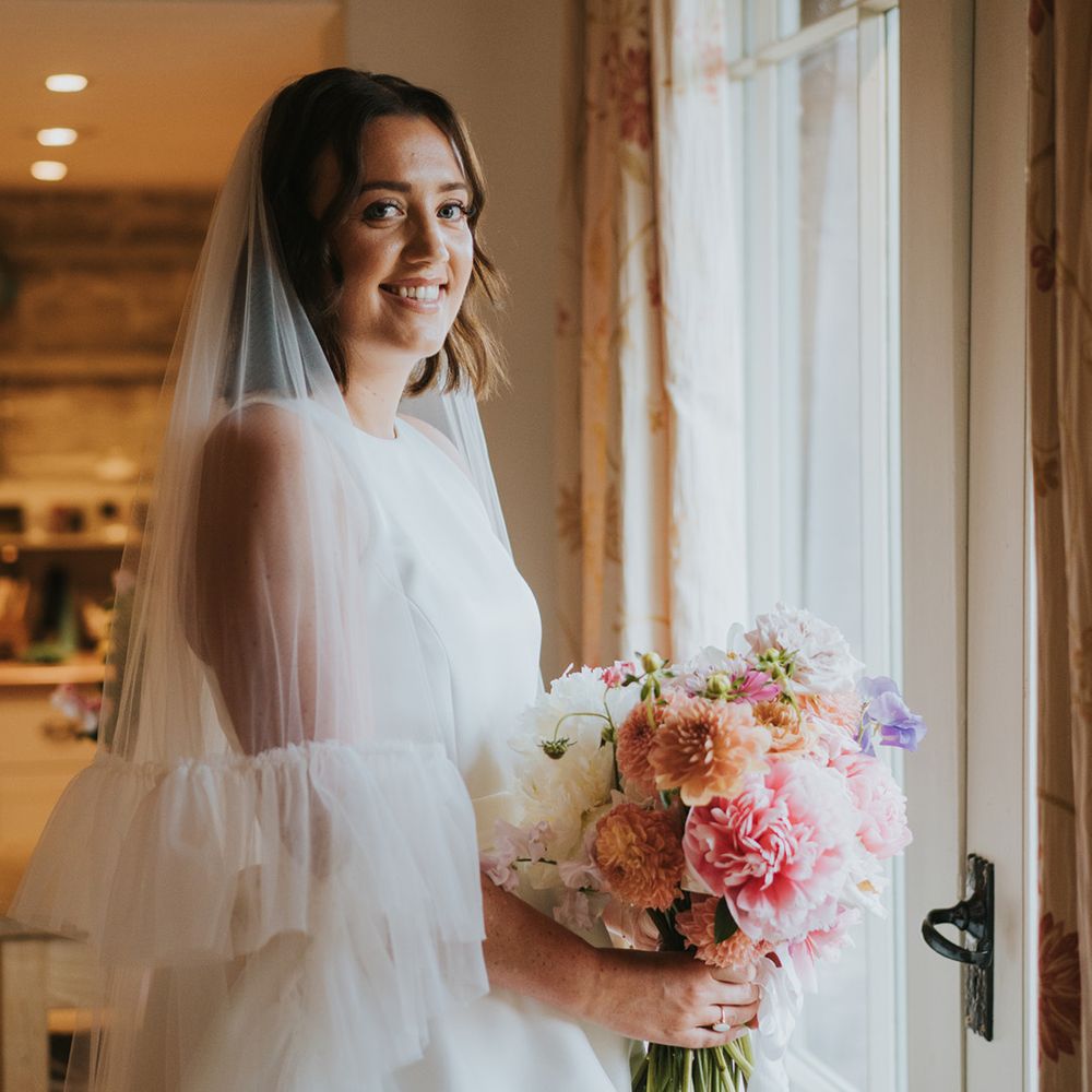 bride-wearing-ruffle-wedding-veil-holding-pastel-wedding-bouquet