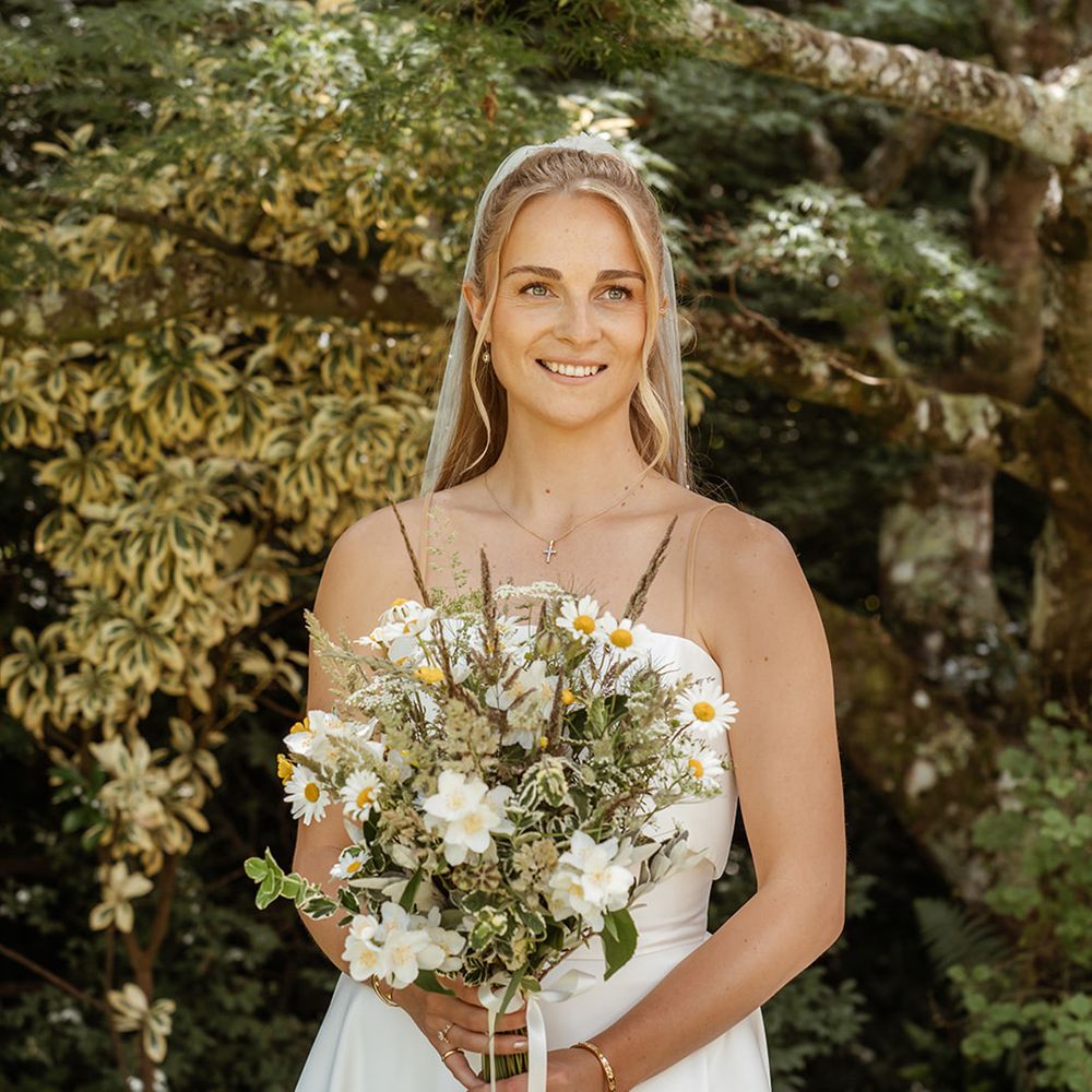 bride-carrying-wildflower-bouquet-with-greenery