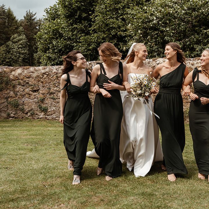 bride-walks-with-bridesmaids-in-dark-green-dresses