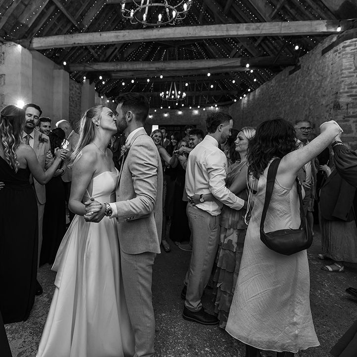 first-dance-moment-with-couple-kissing-in-black-and-white-photo