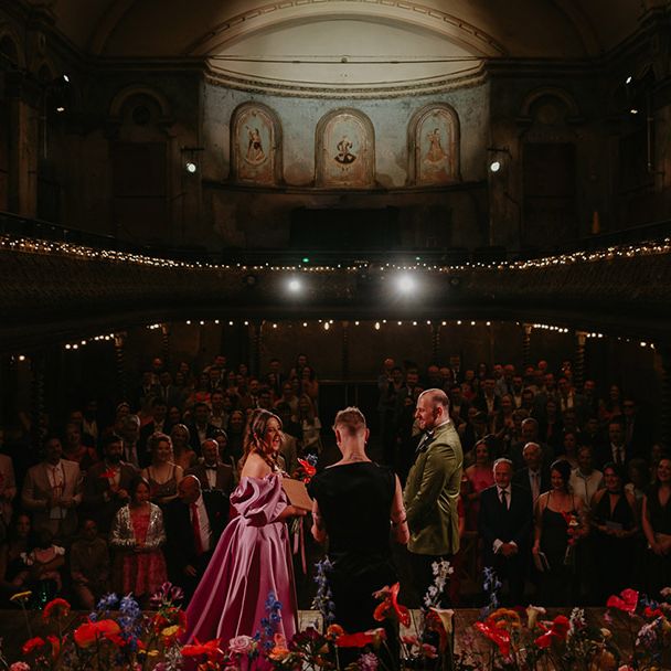 couple-exchanges-vows-in-theatre-hall-in-front-of-audience