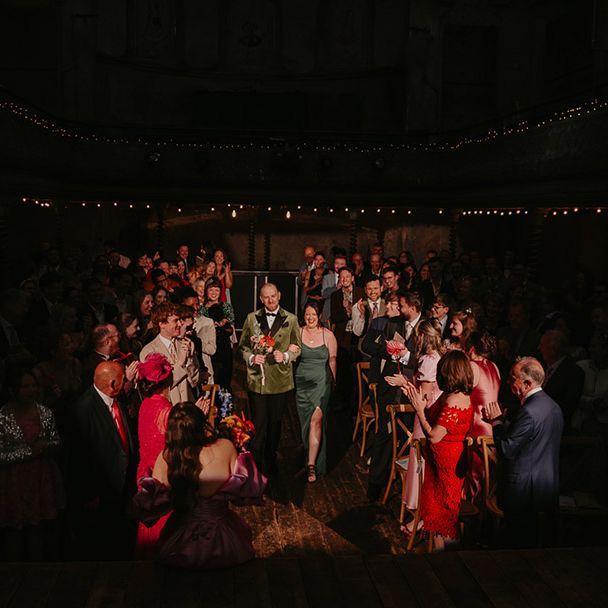 groom-and-best-woman-walk-down-the-aisle-in-dark-green-outfits
