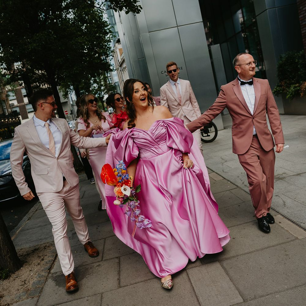 groomsmen-leading-bride-in-pink-wedding-dress-to-ceremony