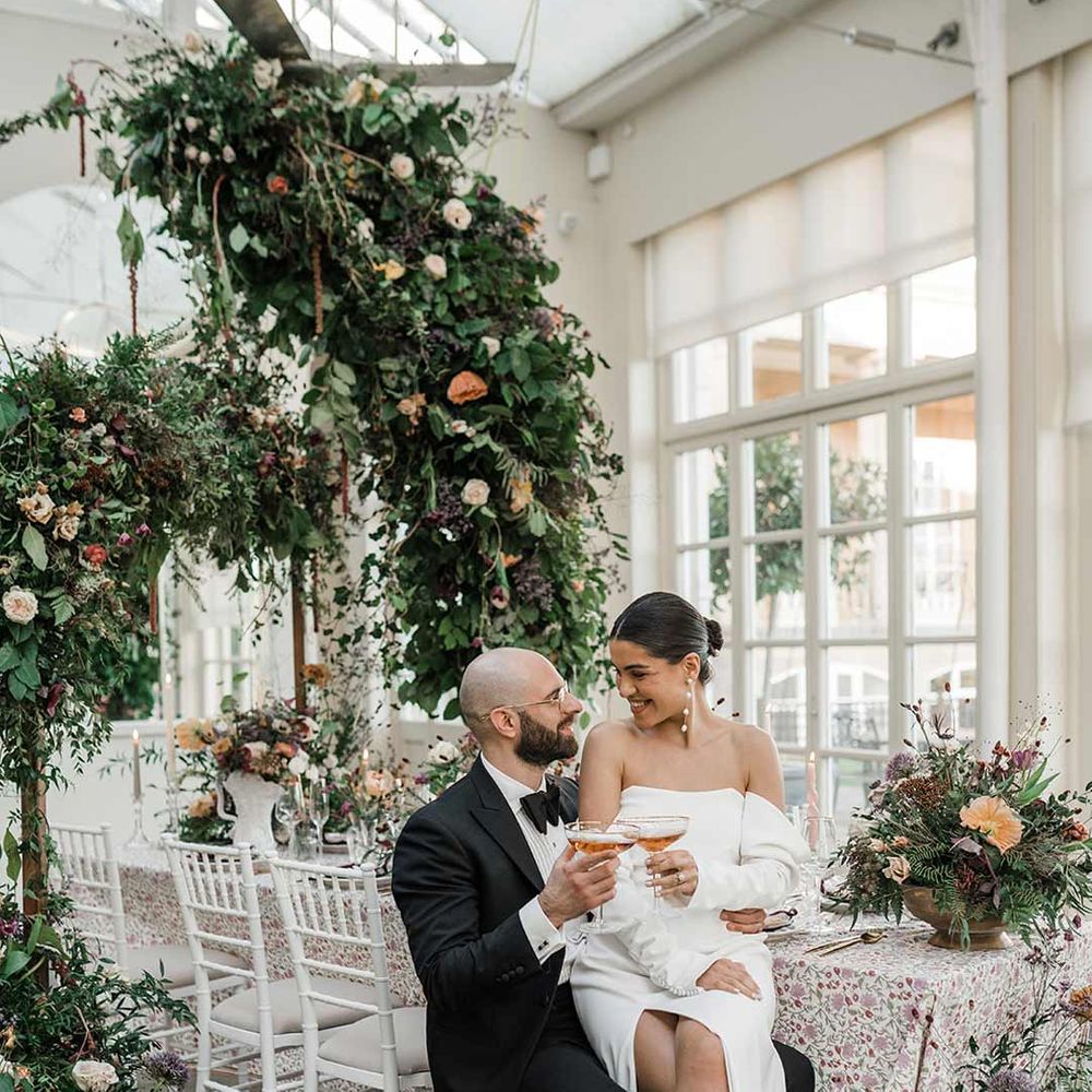 Bride sits on the groom's lap at botanical wedding 