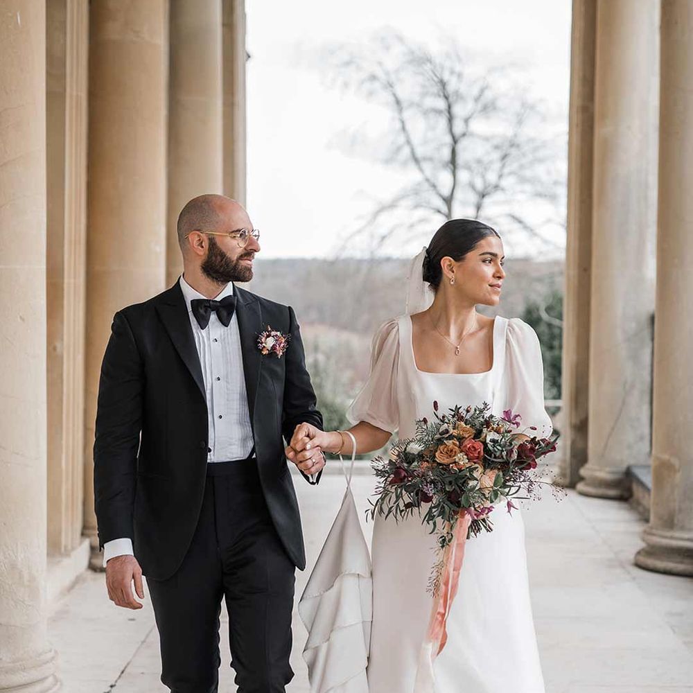Bride and groom in black tie walking around Buxted Park