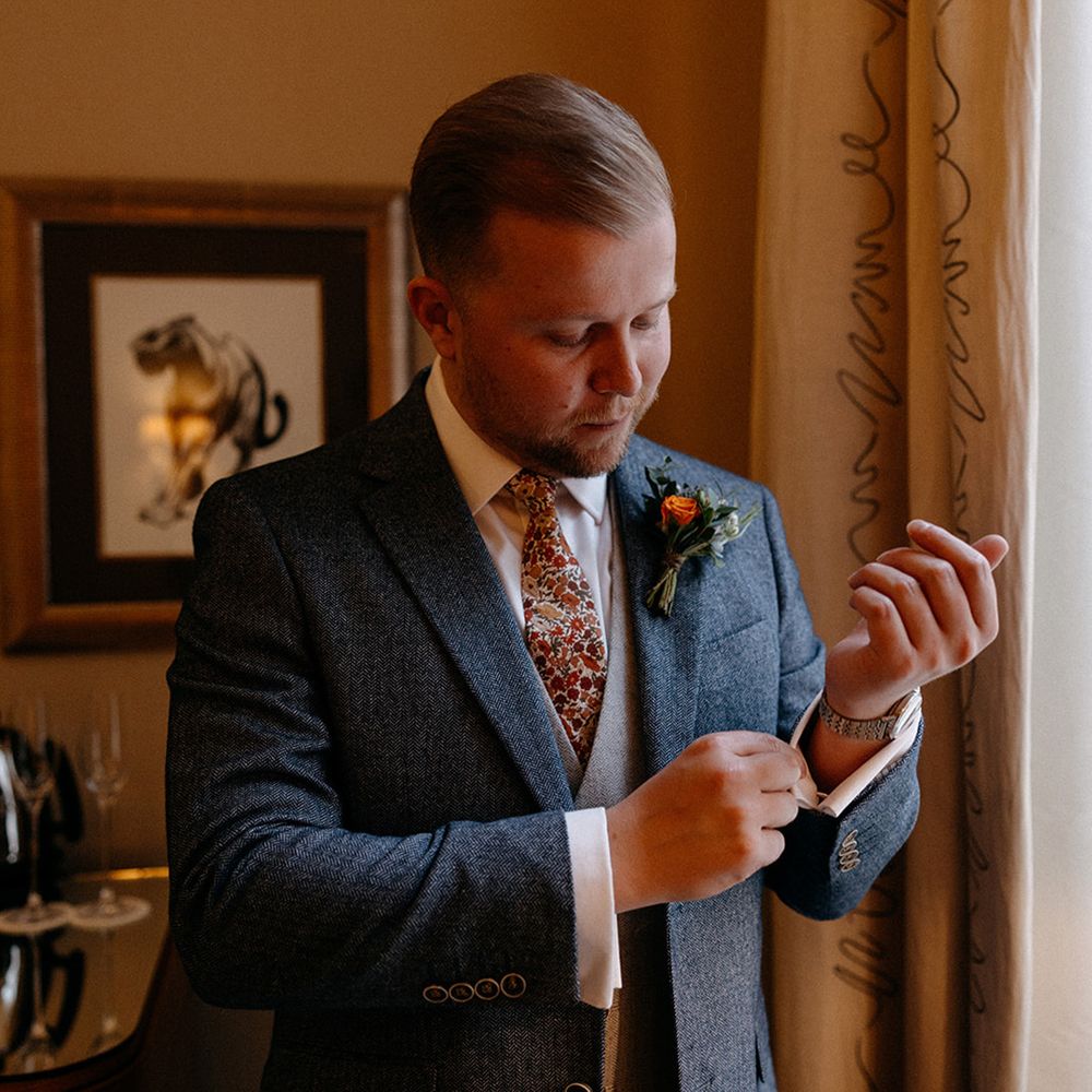 groom-in-blue-wedding-suit-getting-ready-for-wedding