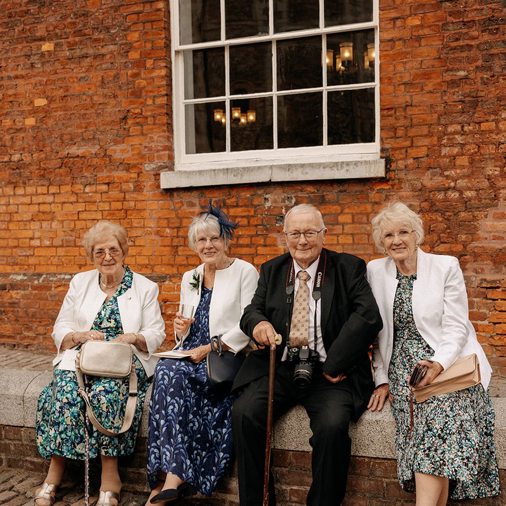 wedding-guests-in-different-colour-dresses-and-white-cardigans-blazers