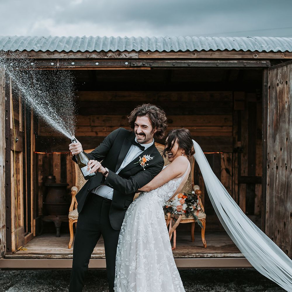 Ghyll Barn lake district wedding venue with couple champagne spray