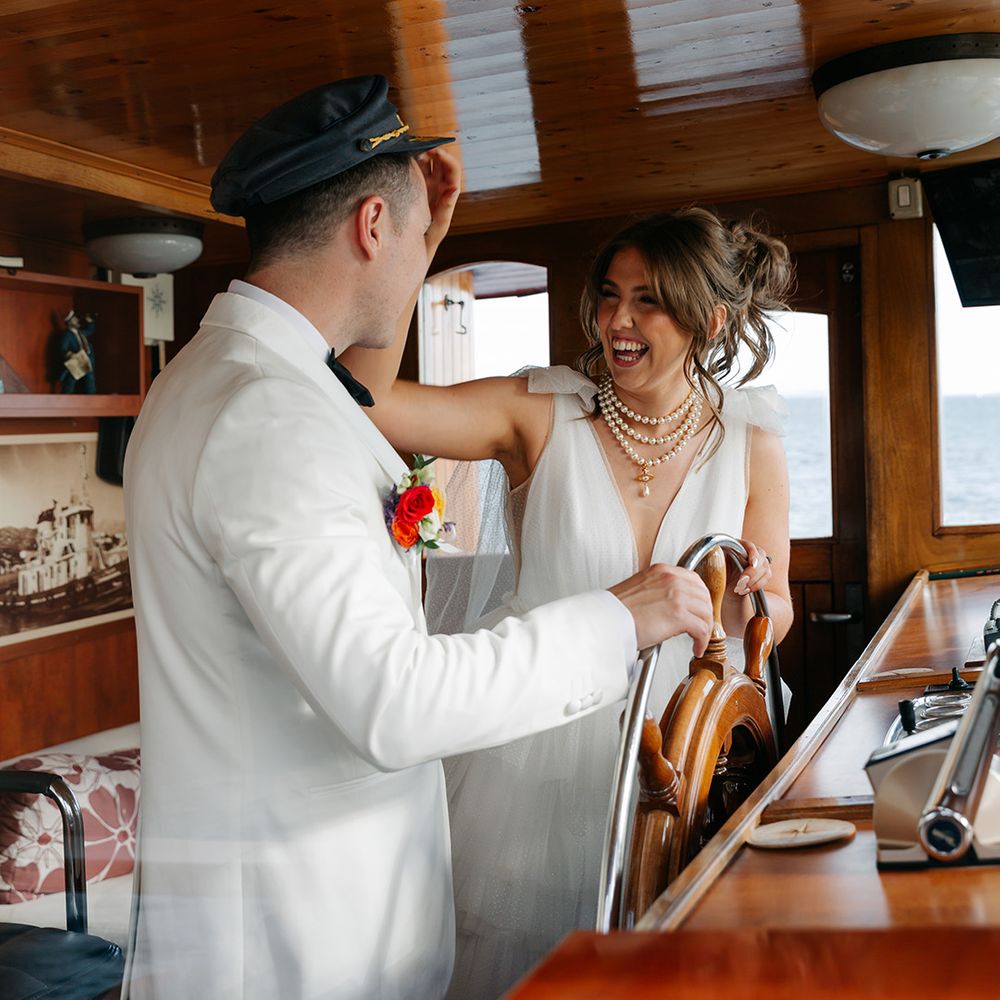 Couple laughs and jokes as they drive the boat