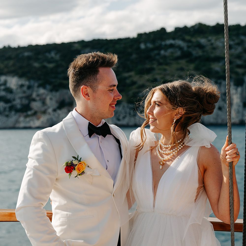 Princess ruffle wedding dress and white tuxedo on wedding boat