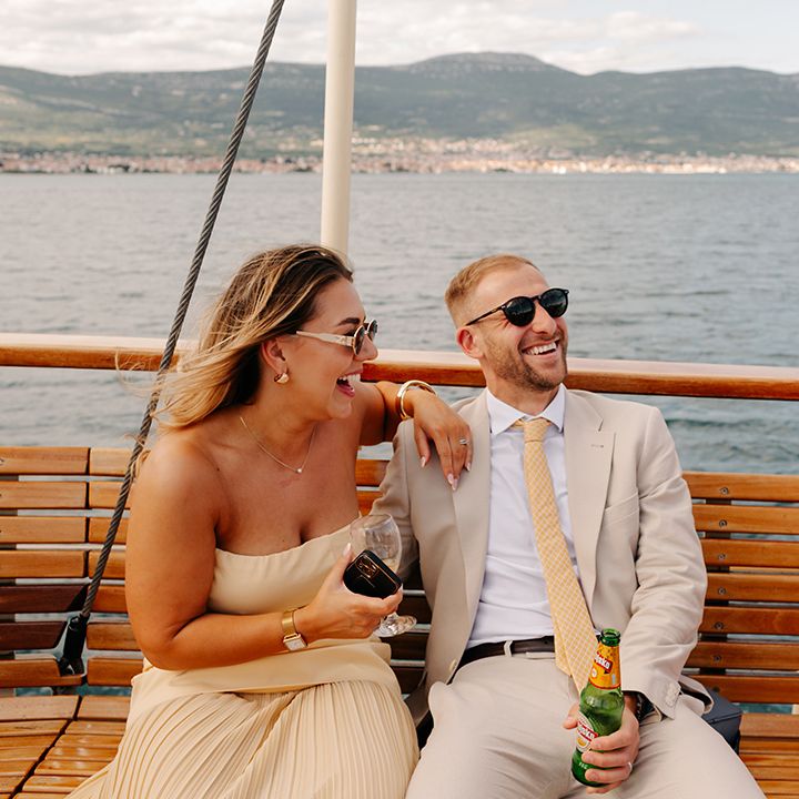 Wedding guests laughing on the boat at fun summer wedding