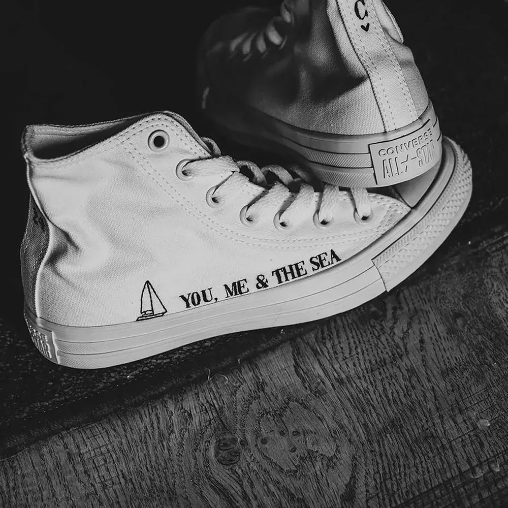 White Converse shoes embroidered with the couple's initials and sentimental saying/quote