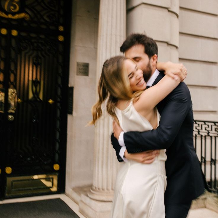 Groom Hugs Bride For Romantic Wedding Portrait At Registry Office Wedding
