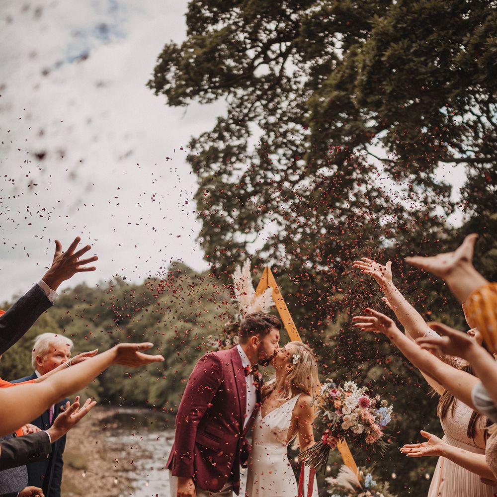 Confetti moment for couple after micro wedding outdoor ceremony