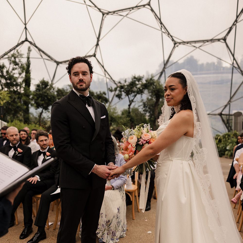 Bride and groom hold hands for their wedding ceremony in unique wedding venue