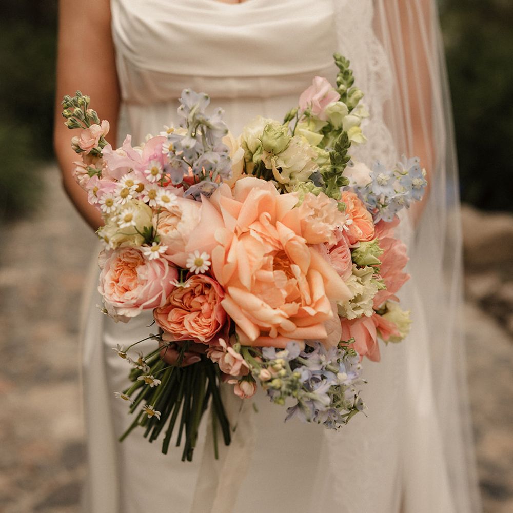 bride-carrying-peach-blue-and-pink-pastel-wedding-bouquet
