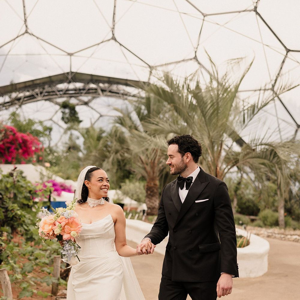 bride-in-corset-wedding-dress-with-front-slit-and-groom-in-black-tuxedo