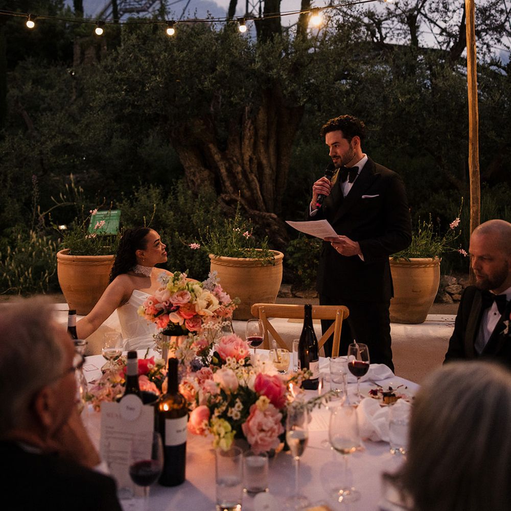bride-smiles-up-at-groom-reading-wedding-speech