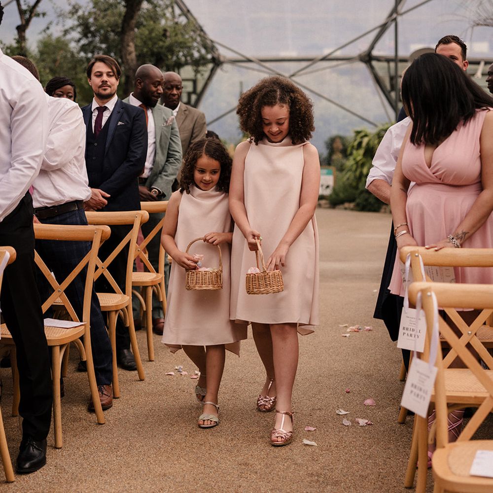 flower-girls-in-pale-pink-dresses-walking-down-the-aisle-together
