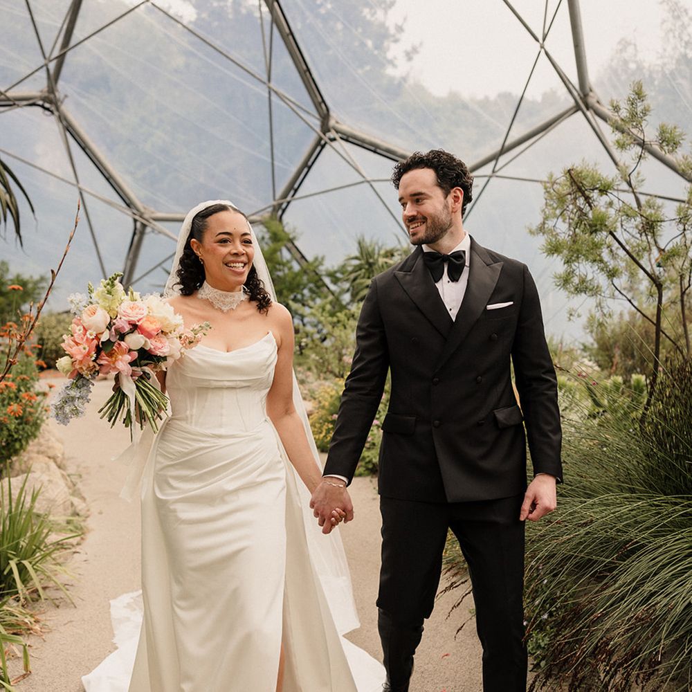 groom-in-black-tuxedo-and-bride-in-strapless-wedding-dress-holding-pastel-bouquet