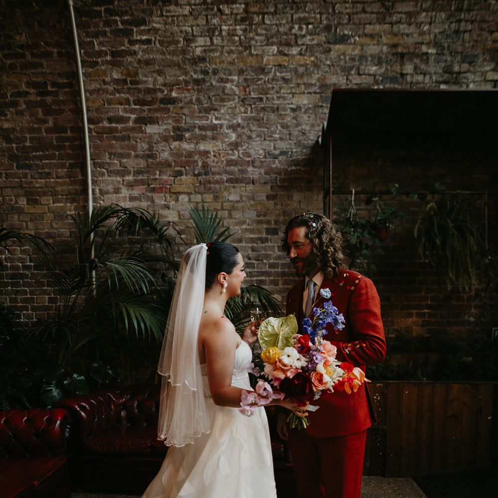 bride-carrying-colourful-wedding-bouquet-facing-groom-at-urban-wedding