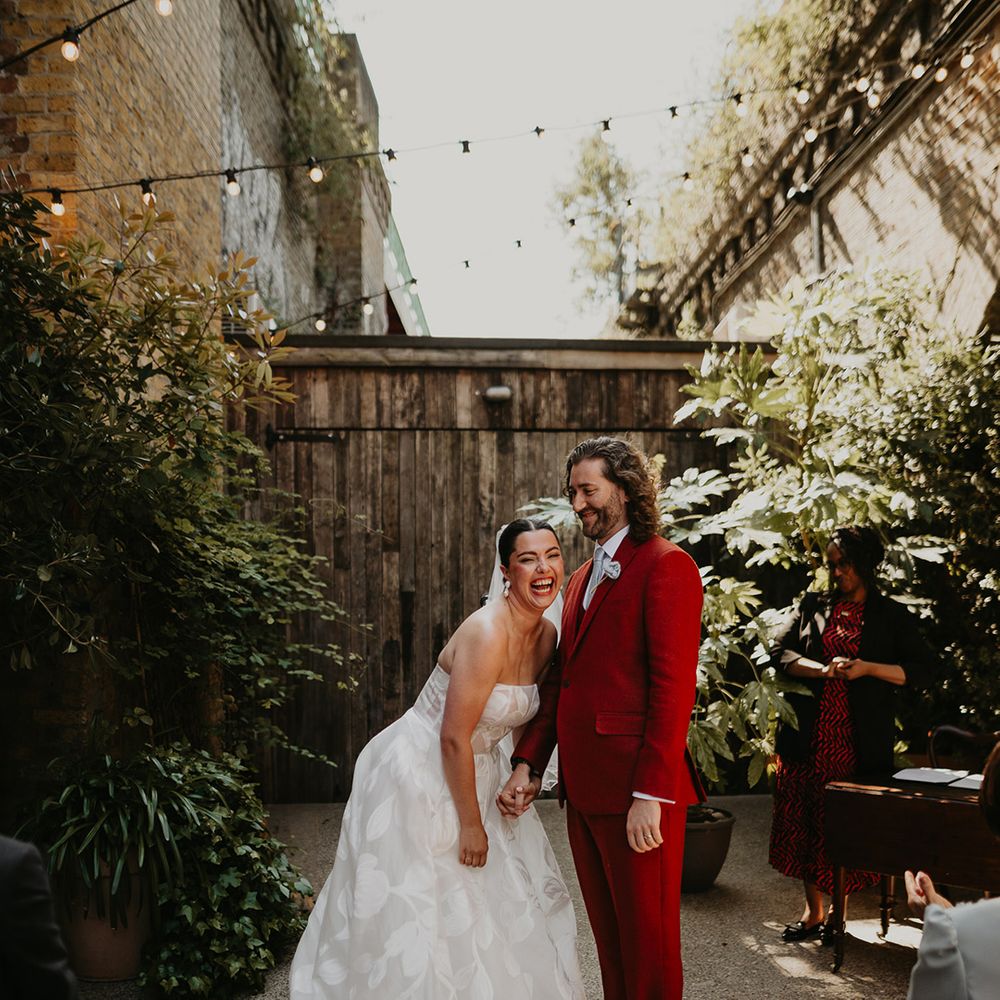 bride-in-strapless-floral-wedding-dress-and-groom-in-orange-suit