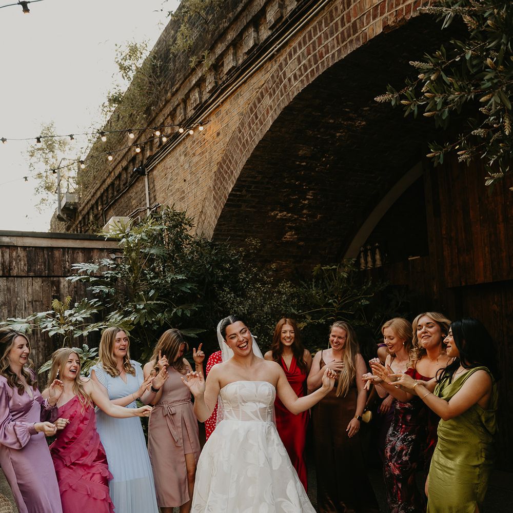 colourful-wedding-guest-dresses-surrounding-bride-in-floral-wedding-dress