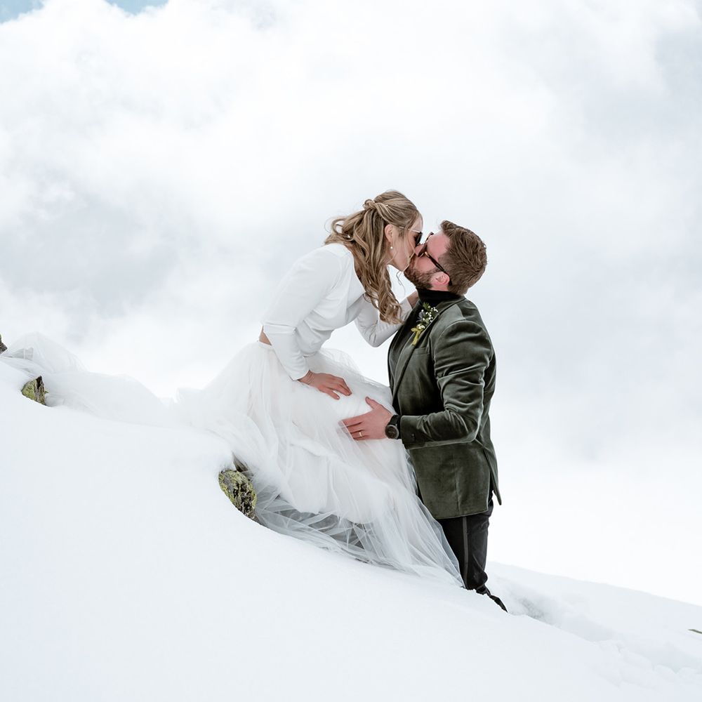 bride-and-groom-kiss-on-snowy-summit
