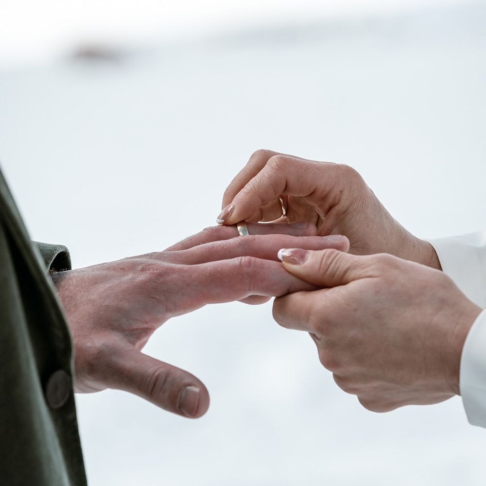 bride-places-wedding-ring-on-grooms-finger
