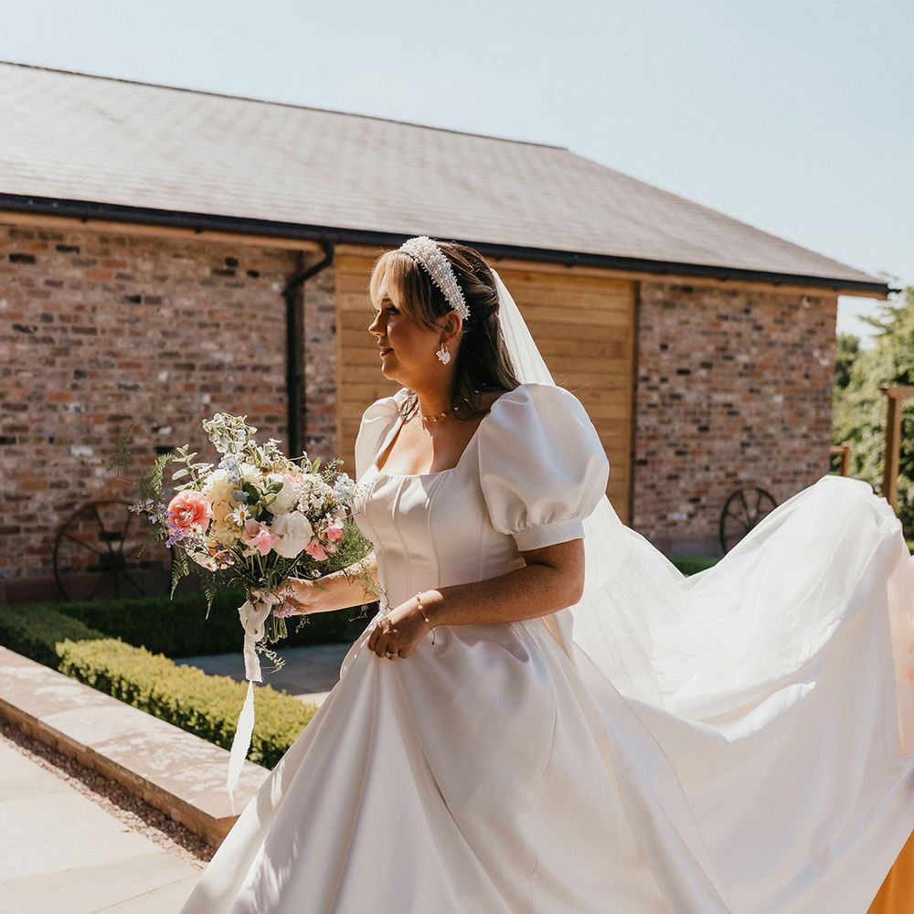 bride-walking-up-steps-in-puff-sleeve-wedding-dress-with-headband