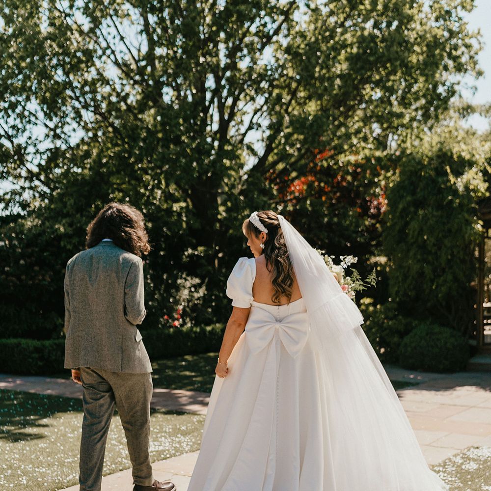 bride-wearing-white-bow-wedding-dress-and-goom-in-green-suit