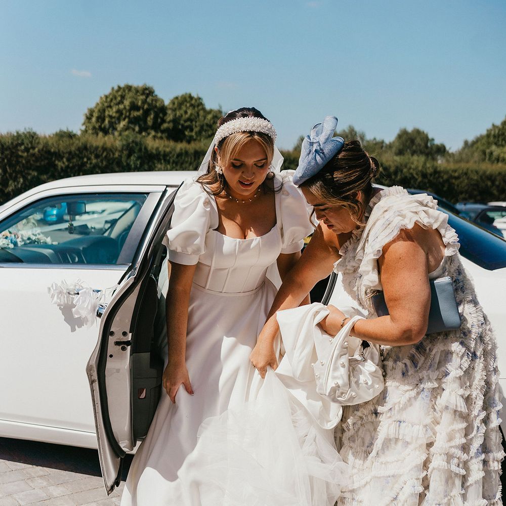 bridesmaid-helps-bride-out-of-the-car.