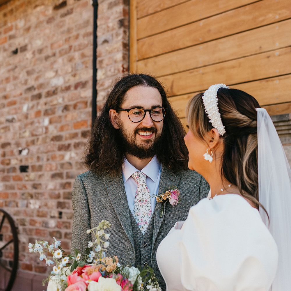 groom-with-long-hair-smiling-at-bride