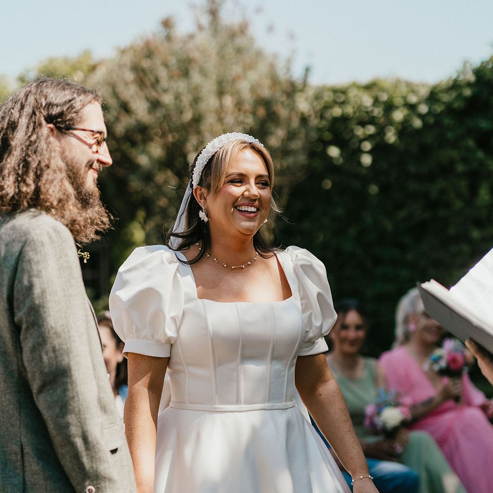 smiling-bride-during-ceremony-in-puff-sleeve-wedding-dress