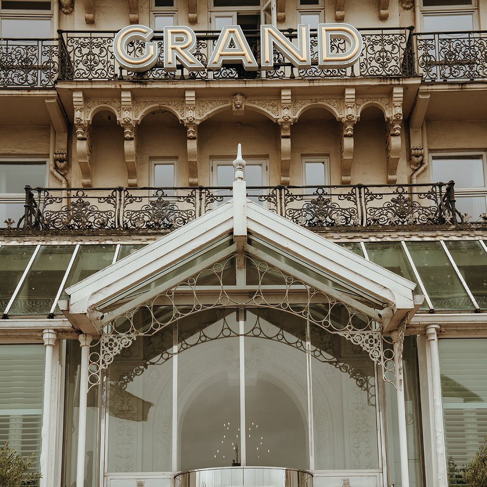 bride-and-groom-pose-outside-of-the-grand-hotel-in-brighton