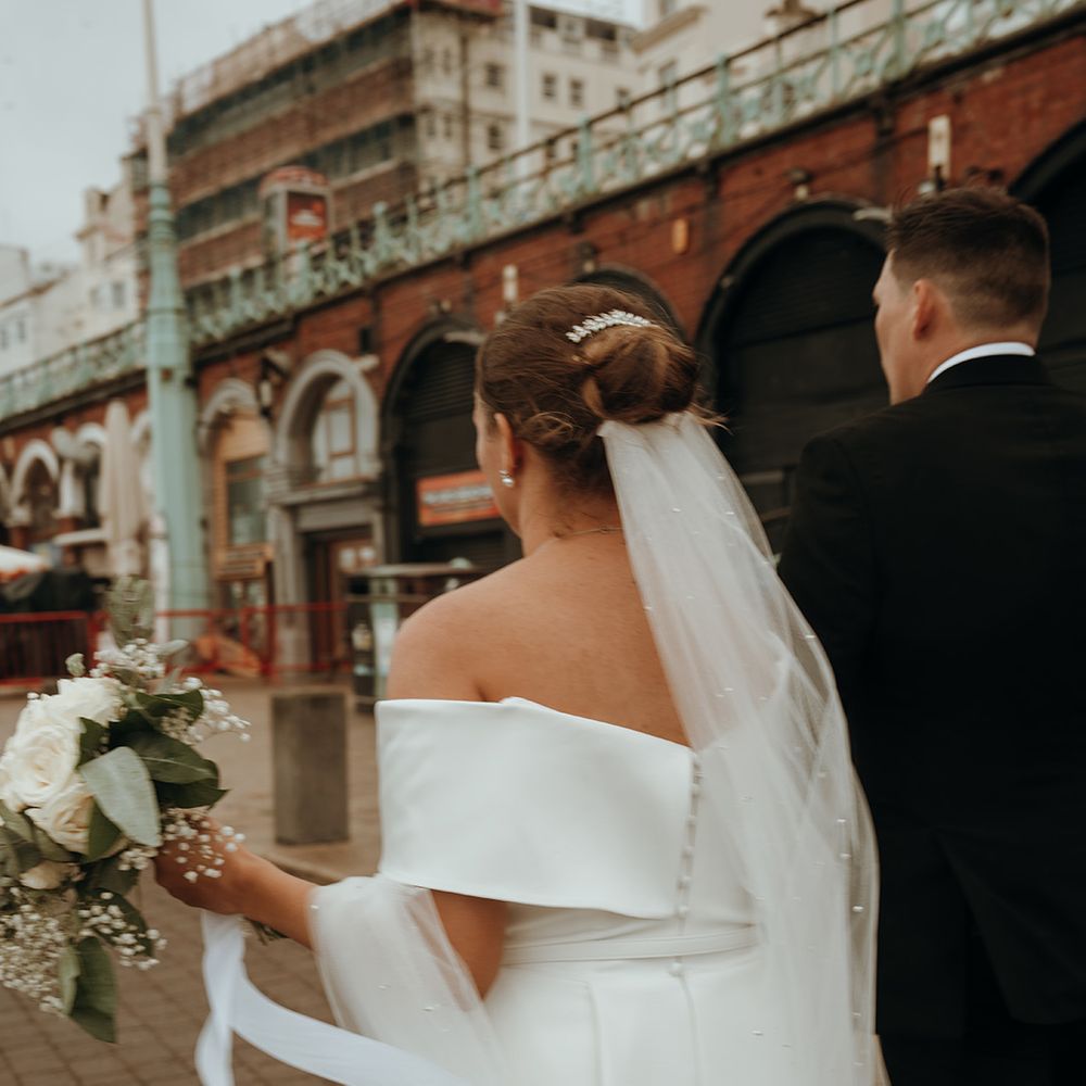bride-with-bun-hairstyle-in-off-the-shoulder-short-wedding-dress-with-groom-in-brighton