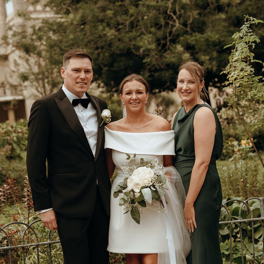 green-bridesmaid-dress-with-bride-in-short-wedding-dress-and-groom-in-black-tuxedo