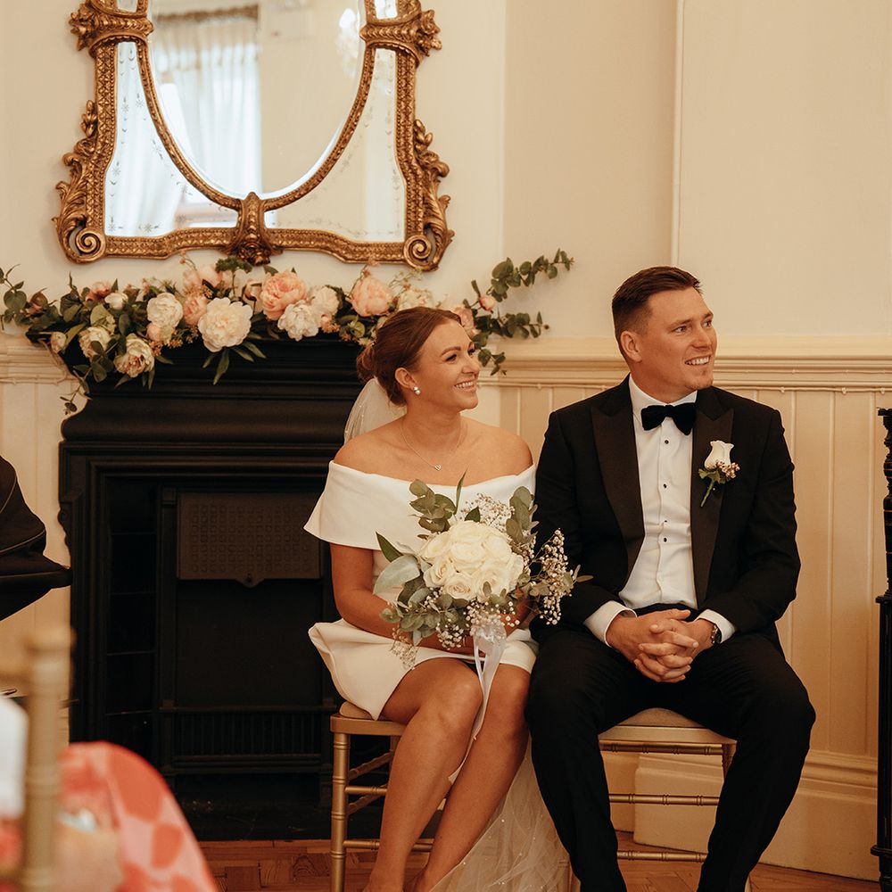 groom-in-black-tuxedo-with-bride-off-the-shoulder-short-wedding-dress