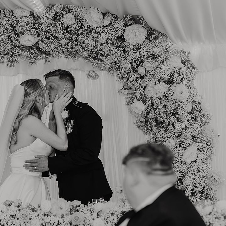 black-and-white-couple-portrait-kiss-in-front-of-flower-arch