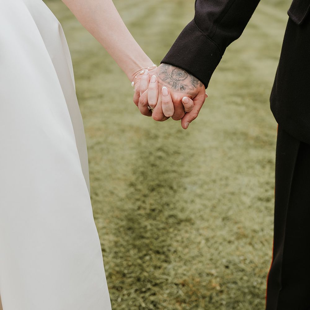 couple-holding-hands-at-wedding