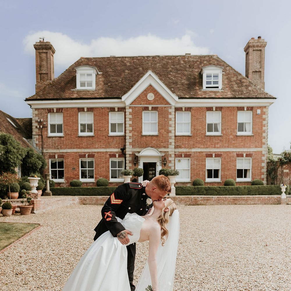couple-kisses-in-front-of-parley-manor-country-house-wedding-venue