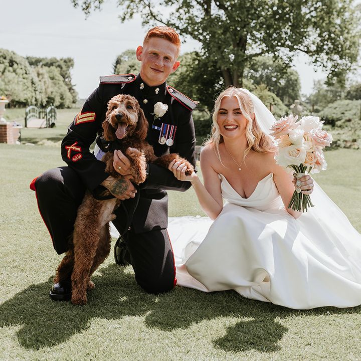 couple-posing-with-their-pet-dog-on-their-wedding-day