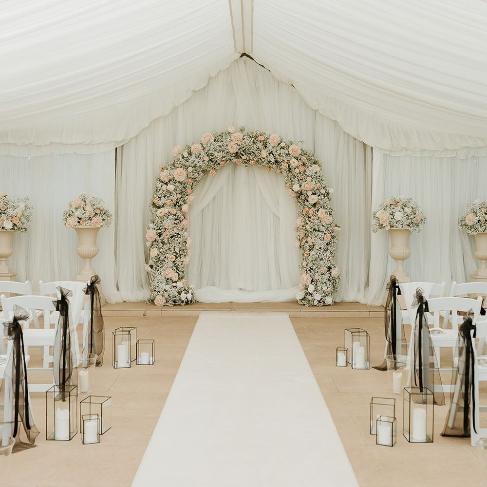 marquee-wedding-ceremony-at-country-house-venue-with-flower-arch