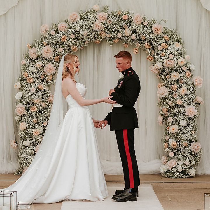 pink-rose-and-gypsophila-flower-arch-with-couple-exchanging-vows