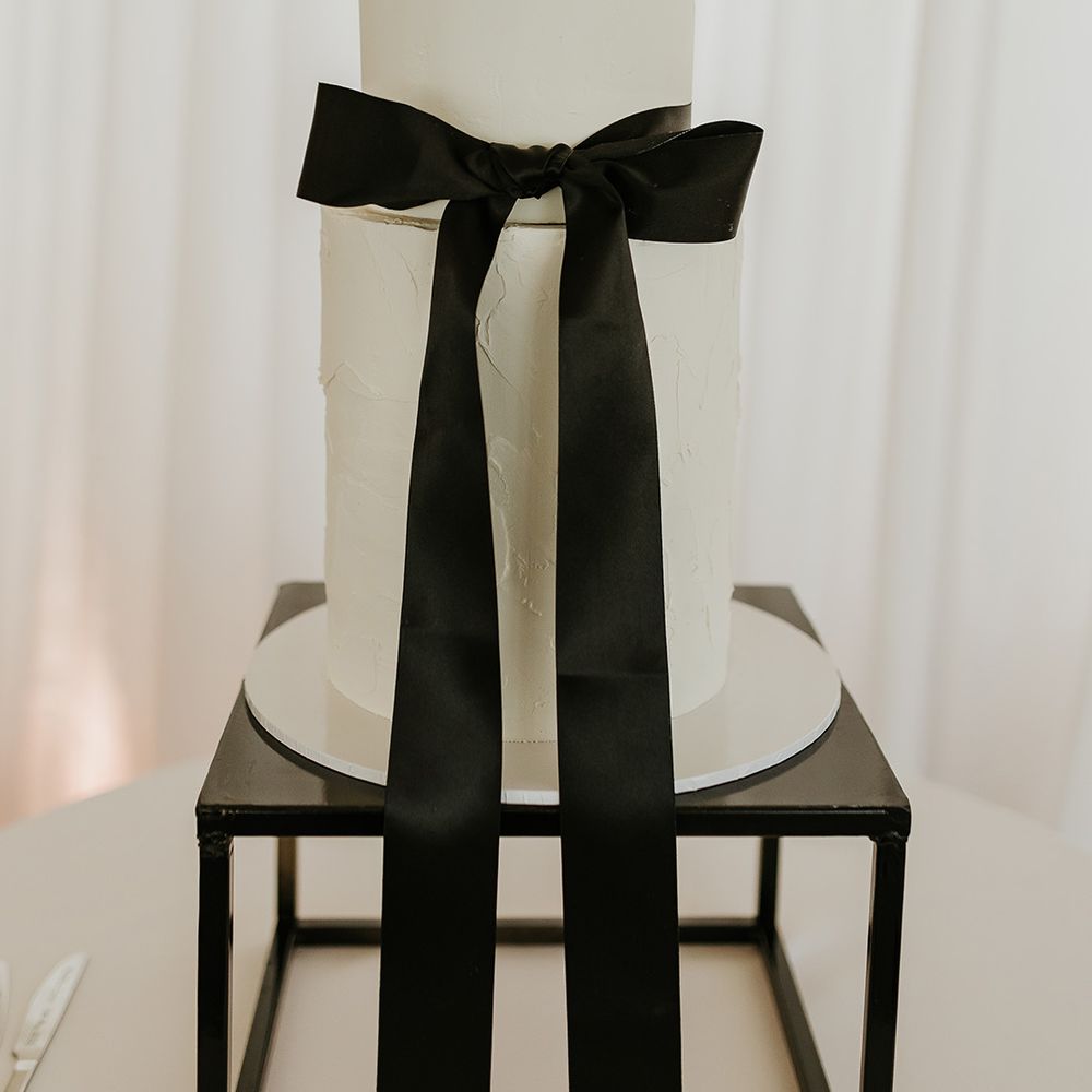 two-tier-iced-white-wedding-cake-with-black-bow