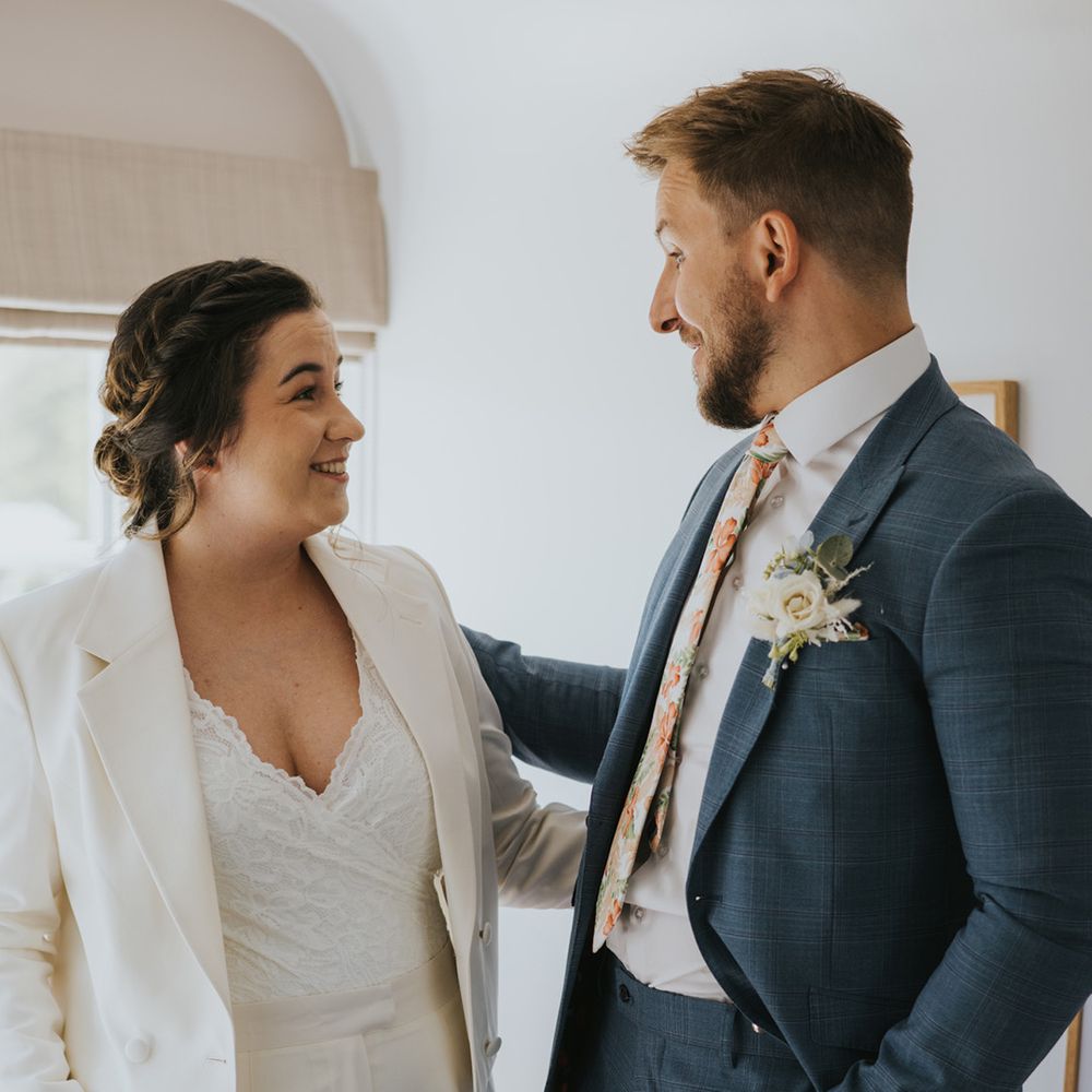 bride-in-white-wedding-suit-with-bridesman-in-dark-blue-suit